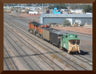 Two engines, two coal cars and caboose in rail yard