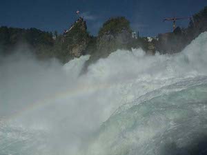 looking into the mid-distance, with the sun at the right angle, the camera catches a rainbow in the midst of the white spray
