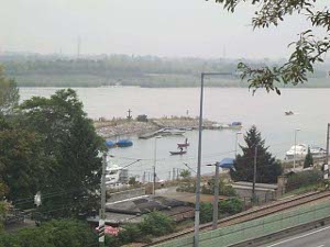 The photo shows the Danube waterfront at Kahlenberg, with two firemen standing in punts training