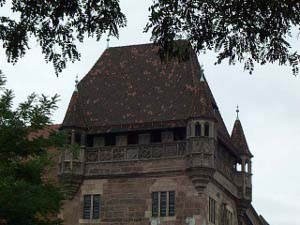 The old house has a steep roof and on the top level is a walk around gallery with octagonal viewing towers at the corners.