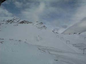Across a field of white are upside-down U-shaped structures which hold the ski lift