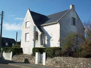 The two story stone house has a steep tile roof