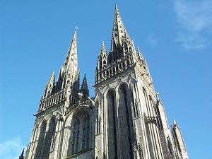 Against a bright blue sky, the towering spires of the Gothic cathedral make a magnificent sight