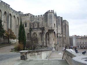 A massive stone palace with crenellated roof, this was both a temporal and spiritual center of power during the period of the French papacy.  Surrounding areas are generally stone pavement, except for a few trees.