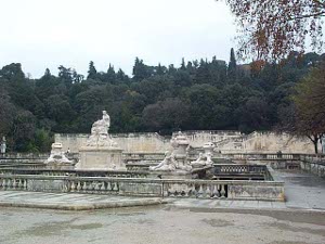 Set behind a low wall on a stone patio, the fountain features large marble sculptures