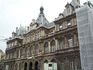 A three-story gabled building with ongoing restoration and maintenance work, this dark stone building dates to the 19th century.