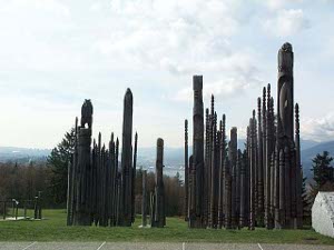 The Japanese carved poles are much more slender than typical Salish totem poles, and of a uniform dark color; they look like a grove of poles.