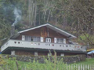Just under the eaves, painted on the wood timbers, is a face of a man; the balcony is decorated with cut-out hearts
