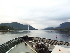 The lookout stands at the bow as the ferry slowly heads north through the channel marked by red and green channel buoys