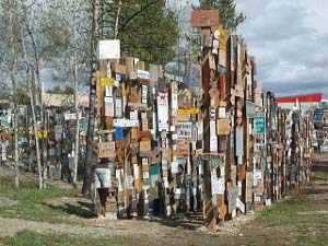 Each wooden post driven in the ground is festooned with colorful signs from all over the world