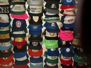 A few dozen baseball-style caps are suspended from the ceiling at the Toad River Lodge