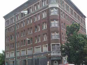 A six story brick building on a street corner in Benton Harbor, completely boarded up, had once been a prosperous commercial center of stores and offices.