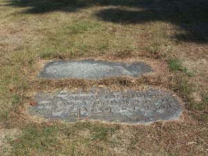 with the green-brown grass encroaching all around the edges, the flat stones lie flush with the ground, side by side, marking the graves of Sudbury's leading 17th century citizen and his wife.