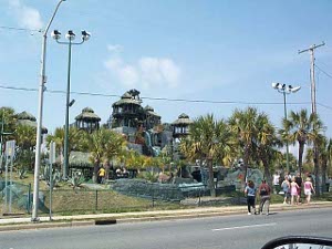 A multi-story building with pseudo thatched huts and many open gazebos on top for some kind of tourist attraction (sign not visible)
