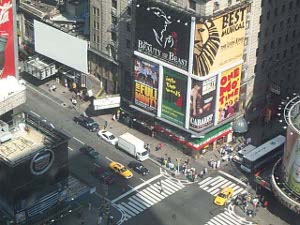 the sides of the buildings are covered with huge theater ads.