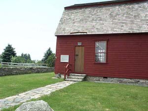 Painted a dark red, the Trumbull store is a plan clapboard building with a steep shingle roof