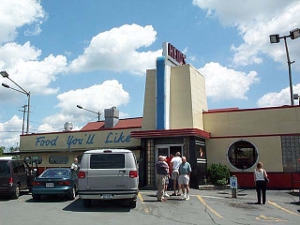 A 1950s building colored light yellow, with red and blue trim