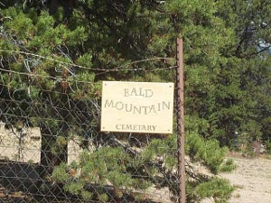 The entrance to the old cemetery is marked by a misspelled sign attached to a flimsy wire fence