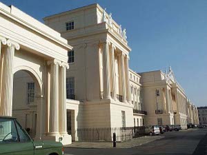 The beautiful Georgian buildings of Cumberland Terrace stand four stories tall, with beautiful Corinthian fluted columns and statues at the top, all in a delicate light peach color, with a neat short iron railing in front.  The heroic scale gives the building lasting elegance.