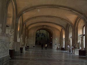 The wide gallery has a gently arching roof and wide arching windows, with marble statues and friezes, giving a feeling of immense size