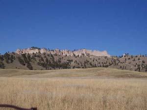 Pinkish rock crowns the top of a miles-long butte rising high above the Wyoming prairie