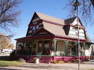 Brightly colored in cream with brown and green trim and rose colored concrete porch steps, the Stevens House in Garden City was on the driving tour.