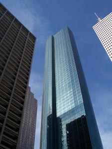 Three modern skyscrapers soar into the blue sky over Houston