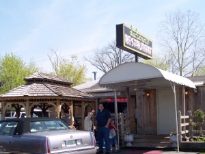 An Awning covers the entranceway and a neon sign urges, 'Y'all come in.'