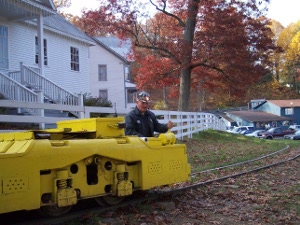 Our guide Sonny sits in the driver's seat of a low-slung yellow electric mine train