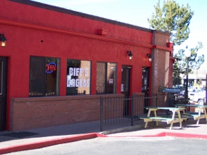 A brightlypainted red store front with a big white sign painted on the window reading Biff's Burgers