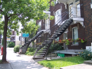 Ornate curving white iron staircases spiral up to second floor apartment doors outside Montreal