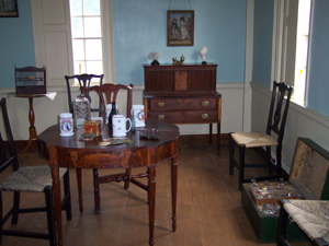 The dining room table in polished and inlaid wood is surrounded by other period
furniture.