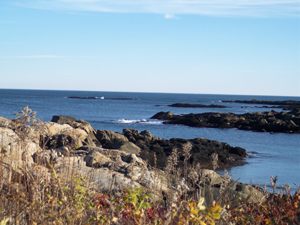 The deep blue ocean is dotted with rocky outcroppings.
