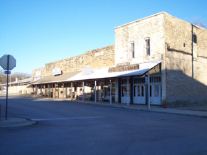 The bleached brick buildings along with the sloping roofs covering the sidewalk
make the deserted buildings look like a Hollywood movie set.