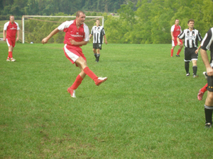 The player for the red team has just passed the ball downfield