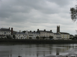 Solid three story brick homes line the street facing the river.
