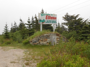 Just above a grass covered root cellar, with a stone front and a wooden door, is a sign proclaming Elliston the root cellar capital of the world.