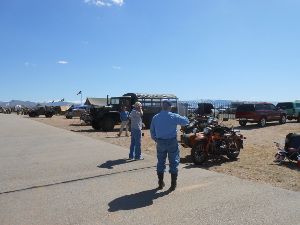 Two men looking at military motorcycles