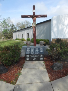 In front of a large representation of Christ on the cross is a low stone monument with the names of veterans from this Mexican American parish.