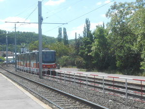 The tram looks like small train cars hitched together