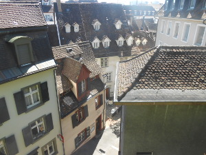 The rooftops are all sharply pointed and a narrow street is visible far below