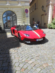 The parked red convertible has the top down so passersby could look inside, as many were doing.  No driver is present, and the police just down the street are not paying any attention to the No Stopping or Parking sign.