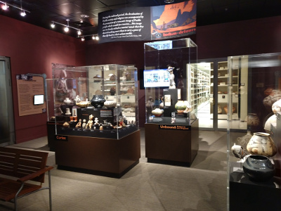 The display room in the foreground contains numerous glass cases of pottery, while the vault, seen through glass doors in the rear, maintains a precise constant temperature and humidity for long-term preservation of pottery.